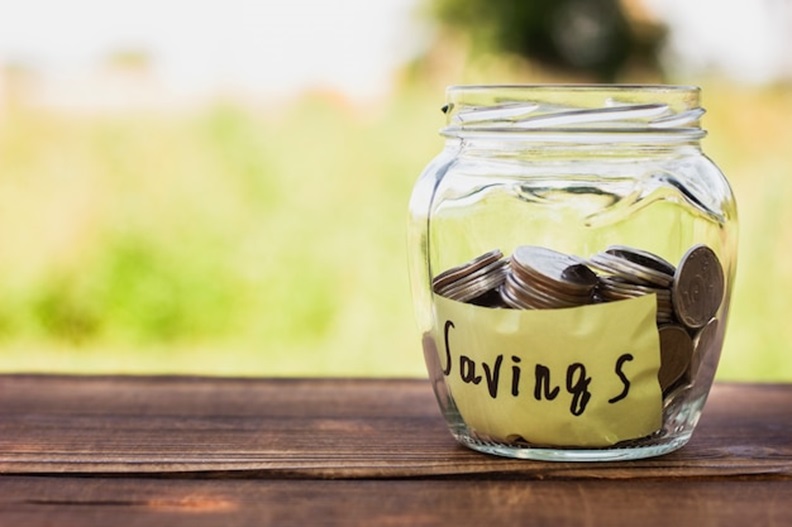 A jar of coins with 'Savings' written on it.
